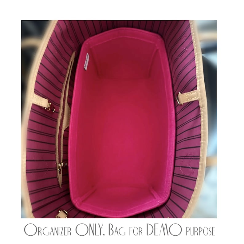 Pu&ograve; includere: Un organizer per borsa in feltro rosa acceso posizionato all'interno di una borsa tote con fodera a righe rosa scuro e nere. L'organizer presenta una forma rettangolare con angoli arrotondati e una piccola etichetta bianca sul lato.