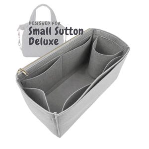 May include: A gray felt bag organizer with multiple compartments and pockets, designed for the Small Sutton Deluxe bag. Features a gold zipper and the text "DESIGNED FOR Small Sutton Deluxe".