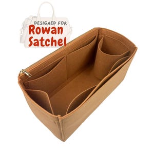 May include: A tan felt bag organizer with multiple compartments and a gold zipper. The text "DESIGNED FOR Rowan Satchel" is visible in the upper left corner. The organizer is designed to fit inside a Rowan Satchel.