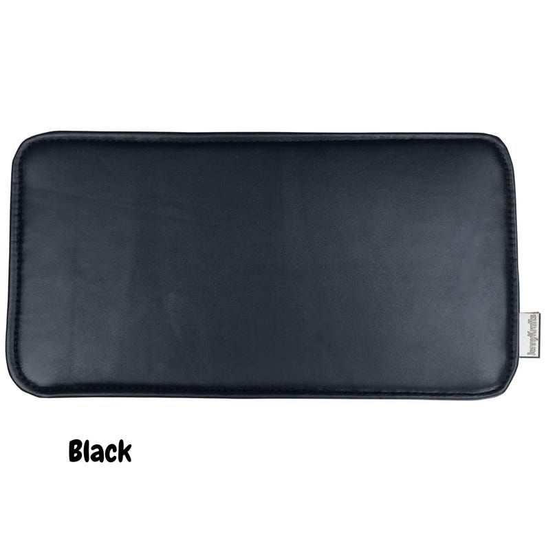 May include: A rectangular black leatherette product with rounded corners. The word "Black" is printed in a bold, white font at the bottom of the image. A small, rectangular tag is on the right side.