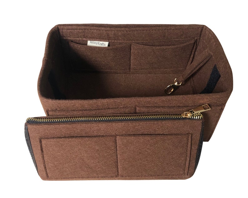 May include: Brown felt handbag organizer with multiple pockets and a zippered compartment. The organizer has a label that says "Jenny Krafts".