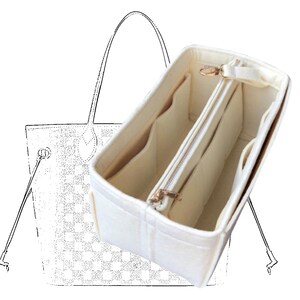 Pode incluir: Um organizador de bolsa de feltro branco com v&aacute;rios compartimentos e fecho de correr. O organizador &eacute; projetado para caber dentro de uma bolsa tote maior.