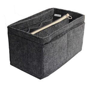 May include: A dark gray felt handbag organizer insert featuring multiple interior compartments, a central zippered pocket with a beige zipper, and a small white rectangular label with the text "JennyKraft" sewn into the inner side wall.