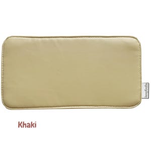 May include: A rectangular, khaki-colored item with rounded corners. The item has a stitched border and a small tag on the right side. The word "Khaki" is displayed in a brown font at the bottom of the image.