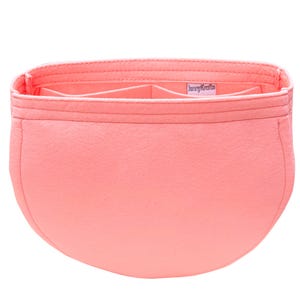 May include: A coral-colored bag organizer with multiple compartments. The organizer is made of a soft material and features a rectangular shape with a curved bottom. The brand name "JennyKrafts" is visible on a small label inside the organizer.