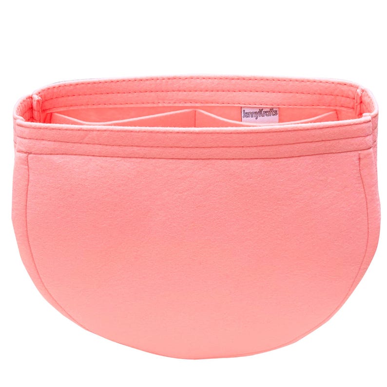 May include: A coral-colored bag organizer with multiple compartments. The organizer is made of a soft material and features a rectangular shape with a curved bottom. The brand name "JennyKrafts" is visible on a small label inside the organizer.