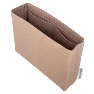 Peut inclure: Organisateur de sac en feutre beige avec plusieurs compartiments. L'organisateur rectangulaire comporte plusieurs poches intérieures et est conçu pour être placé à l'intérieur d'un sac plus grand. L'article porte une étiquette "JennyKraftz".