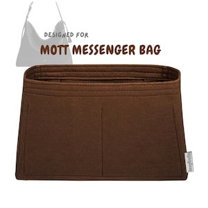 以下が含まれることがあります： 「DESIGNED FOR MOTT MESSENGER BAG」の文字が入った茶色のフェルトバッグオーガナイザー。オーガナイザーには複数のコンパートメントがあり、メッセンジャーバッグの内側に収まるように設計されています。オーガナイザーは長方形で、ステッチされたボーダーがあります。