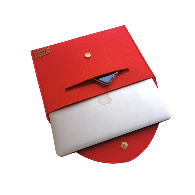 Pu&ograve; includere: Custodia per laptop in feltro rosso con una piccola tasca per il telefono. La custodia ha una chiusura a bottone dorata.