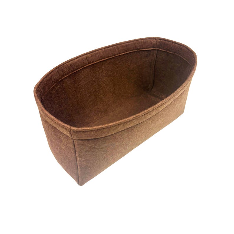 Pu&ograve; includere: Un organizer per borsa in feltro marrone con apertura ovale e design strutturato a parte superiore aperta. L'interno presenta una consistenza liscia e uniforme con cuciture lungo il bordo superiore e i lati, offrendo uno spazio profondo.