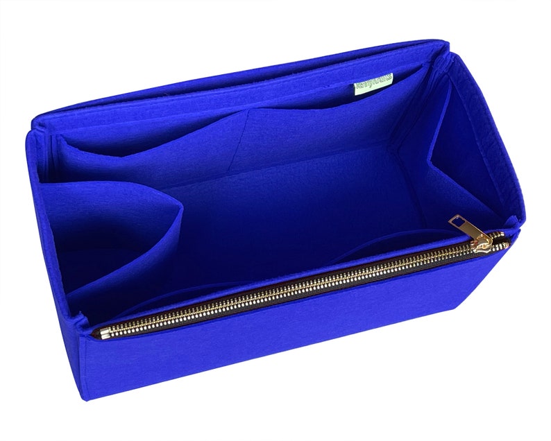 May include: Blue felt bag organiser with multiple pockets and a zipper closure. The organiser is designed to fit inside a larger bag.