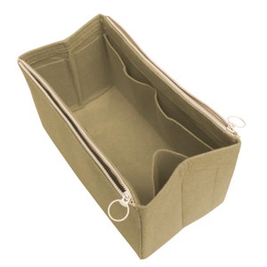 Puede incluir: Organizador de bolso de fieltro beige con m&uacute;ltiples compartimentos y cierre de cremallera. El organizador tiene dos tiradores de cremallera con anillos met&aacute;licos.