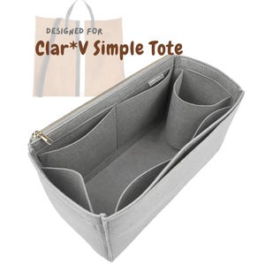 May include: A light gray tote bag organizer with multiple compartments and a zippered closure. The organizer is designed to fit inside a tote bag and features various pockets for organization. The text "DESIGNED FOR Clar*V SIMPLE TOTE" is visible.