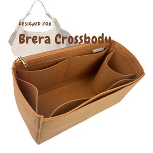May include: A tan felt handbag organizer insert with multiple interior pockets and a gold-tone zipper closure. The text "DESIGNED FOR Brera Crossbody" is printed above a small white handbag illustration in the background of the image.