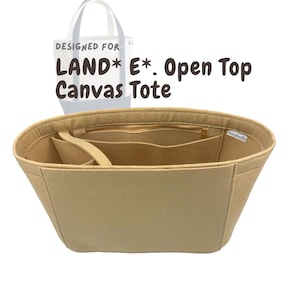 May include: Beige felt tote bag organizer with multiple compartments and a zippered top. The text "DESIGNED FOR LAND* E*. Open Top Canvas Tote" is visible in the background. The organizer is designed to fit inside a tote bag.