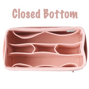 Puede incluir: Un organizador de bolso de mano de fieltro rosa con múltiples compartimentos. El organizador tiene un fondo cerrado y está diseñado para mantener los artículos organizados dentro de un bolso o tote bag. El texto "Closed Bottom" se muestra en la parte superior.