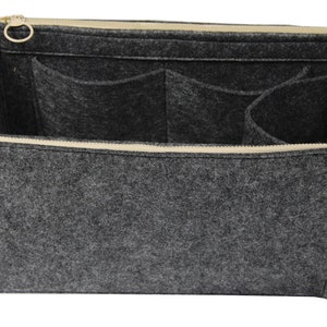 Puede incluir: Organizador de bolso de fieltro gris con m&uacute;ltiples bolsillos y cierre de cremallera. El organizador tiene una cremallera beige y herrajes dorados.