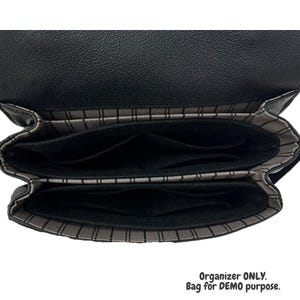 Puede incluir: Organizador de bolsa de tela negro con dos compartimentos y un forro a rayas. Organizador SOLO. Bolsa para fines de DEMO.