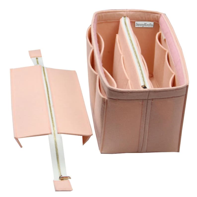 May include: A light peach-colored felt handbag organizer with multiple interior compartments and a removable center section featuring a white zipper. A small white label with the text JennyKraft is attached to the inner wall of the organizer.