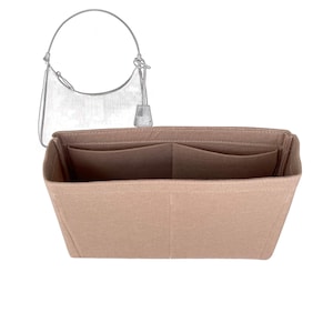Pode incluir: Um organizador de bolsa de feltro bege com dois bolsos grandes e dois bolsos menores. O organizador é projetado para caber dentro de uma bolsa de mão.