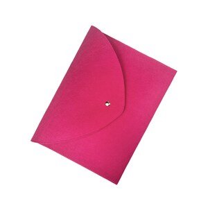 Pu&ograve; includere: Una busta in feltro rosa brillante con chiusura a bottone dorata.