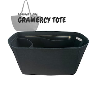 May include: Black tote bag organiser with multiple compartments and a zipped pocket. The text "DESIGNED FOR GRAMERCY TOTE" is displayed above the organiser. The organiser is designed to fit inside a tote bag.