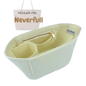 Puede incluir: Organizador de bolso de fieltro color crema con múltiples compartimentos y un bolsillo con cremallera. El organizador está diseñado para encajar dentro de un bolso tote Neverfull. El texto "DESIGNED FOR Neverfull" es visible en el fondo.
