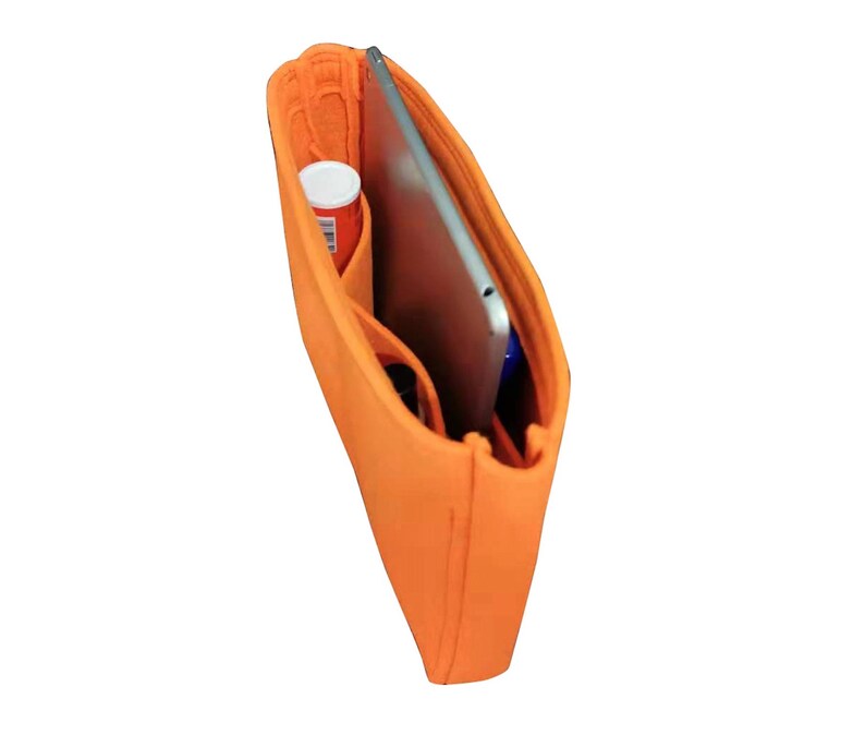 Op de afbeelding: Oranje gevoerde tasorganizer met meerdere vakken en compartimenten. Een tablet is zichtbaar in de tas.