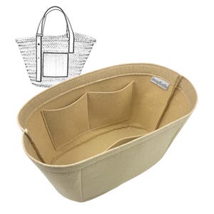 Puede incluir: Organizador de bolso de fieltro beige con múltiples bolsillos, diseñado para caber dentro de un bolso tote. El organizador tiene forma rectangular con la parte superior curvada y una etiqueta que dice "LavyKrafts". Un boceto de un bolso tote de paja está en el fondo.