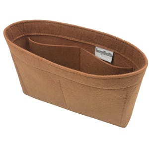 May include: A brown felt handbag organizer with multiple compartments. The organizer has an oval shape and includes a label that reads "JennyKrafts". The organizer is designed to help keep the contents of a handbag organized.