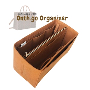 May include: A tan felt bag organiser with multiple compartments and a zipped pocket. The organiser is designed to fit inside a handbag and features the text "DESIGNED FOR Onth.go Organizer".