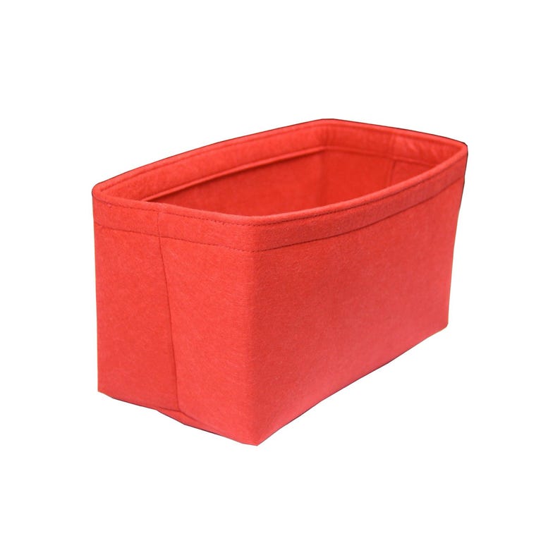 Pu&ograve; includere: Un organizer rettangolare realizzato in feltro rosso brillante. Il contenitore presenta un design strutturato con apertura superiore, cuciture rinforzate lungo i lati e un bordo spesso ripiegato sulla parte superiore per una maggiore stabilit&agrave;.