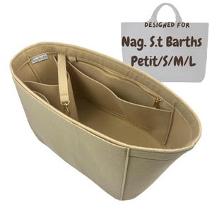 May include: Beige felt handbag organizer with multiple compartments, including a zippered pocket and a detachable strap. The organizer is designed to fit a Nag. St Barths Petit/S/M/L bag. The text "DESIGNED FOR Nag. St Barths Petit/S/M/L" is visible.