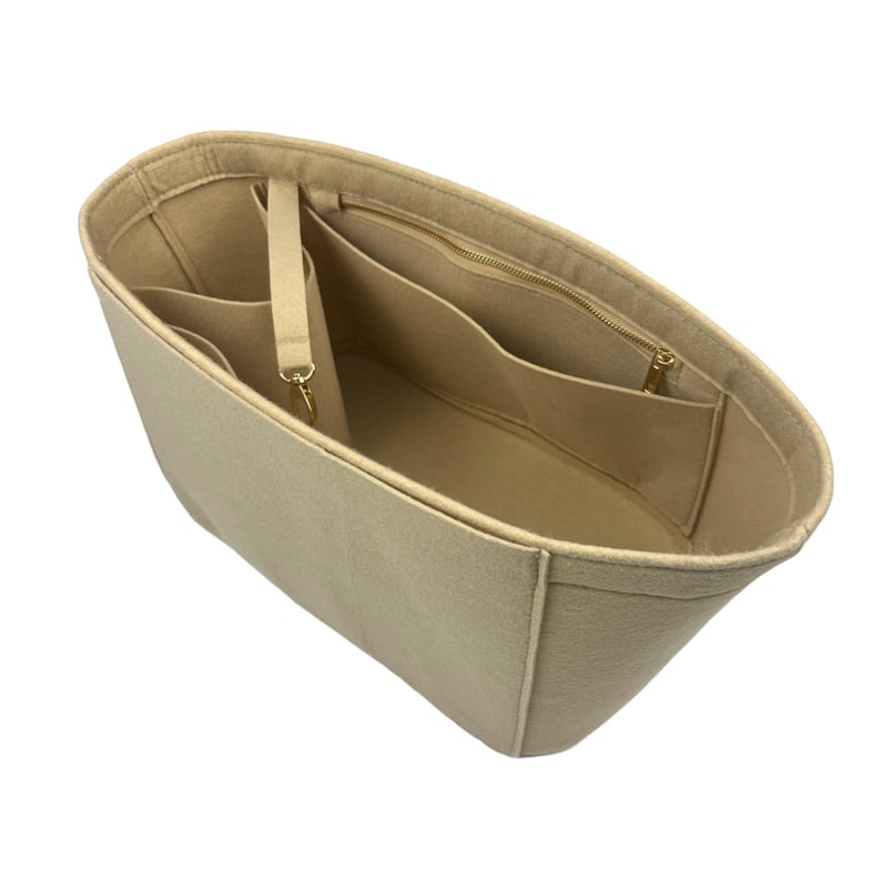 May include: Beige felt bag organizer with multiple pockets and a zippered compartment. The organizer has a strap for attaching to a key ring.