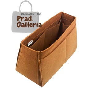 Könnte beinhalten: Ein brauner Filz-Handtaschen-Organizer mit mehreren Fächern und Taschen. Der Organizer ist für den Einsatz in einer Handtasche konzipiert. Der Text "DESIGNED FOR Prad. Galleria" ist im Bild zu sehen.