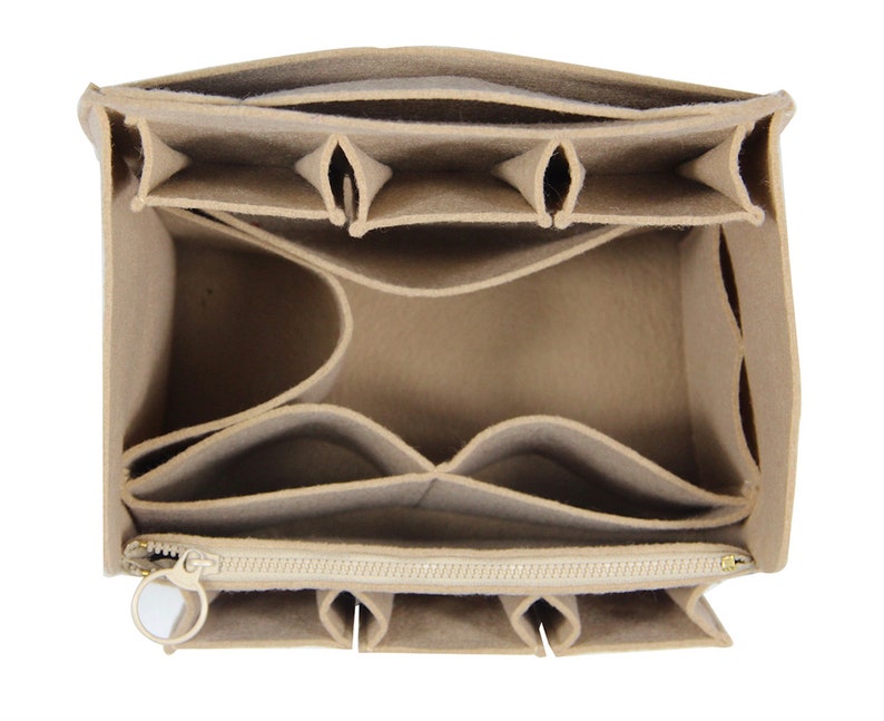 Op de afbeelding: Beige felt handtaschenorganizer met meerdere vakken en een ritsvak. De organizer heeft een beige rits met een gouden trekkoord.