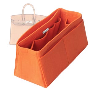 May include: An orange felt handbag organizer with multiple compartments and pockets. The organizer is designed to fit inside a handbag and features a rectangular shape with a structured design. A sketch of a handbag is in the background.