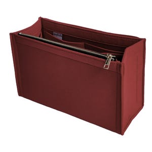 Op de afbeelding: Een bordeauxrode vilten handtassenorganizer met meerdere compartimenten en een ritssluiting. De organizer heeft een rechthoekige vorm en is ontworpen om in een grotere tas te passen. De rits en hardware zijn zilverkleurig.