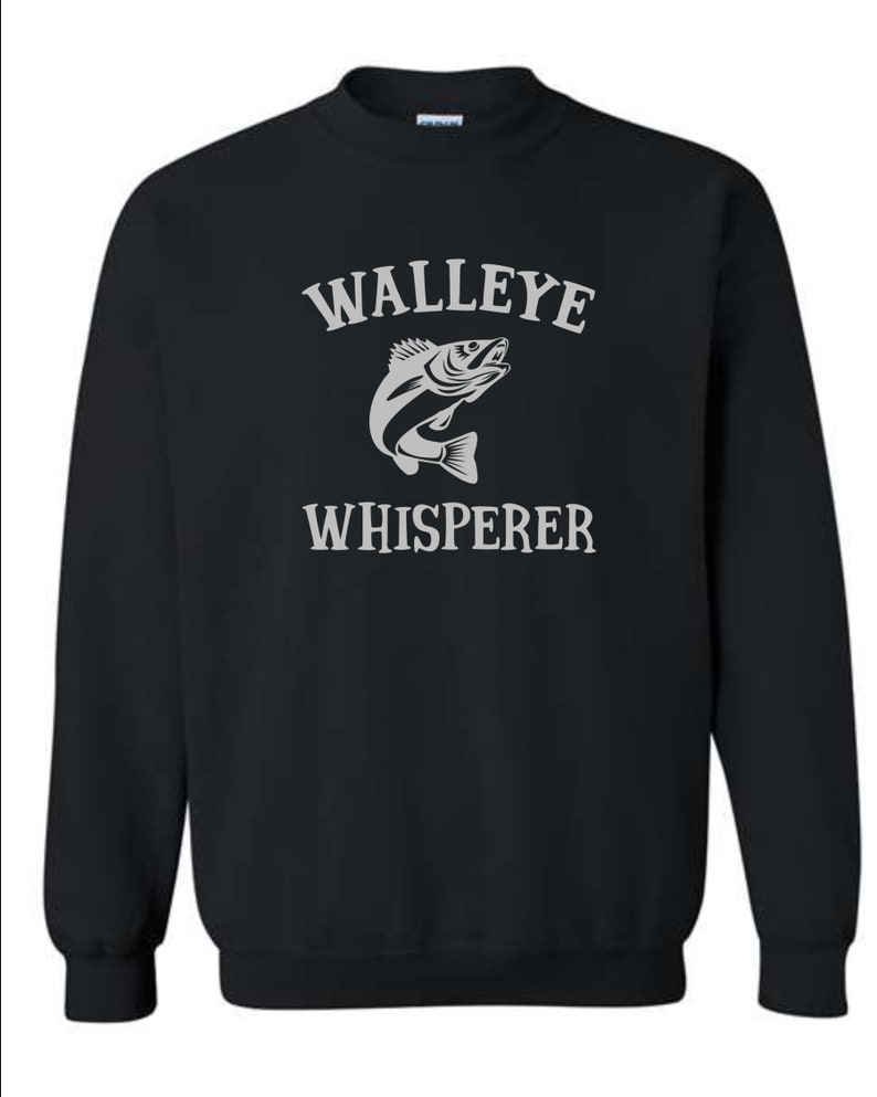 K&ouml;nnte beinhalten: Schwarzer Pullover mit einem wei&szlig;en Aufdruck eines Zanders und dem Text "WALLEYE WHISPERER".