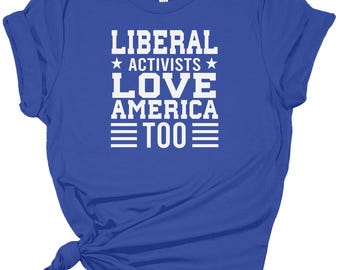 Puede incluir: Una camiseta azul real con texto blanco que dice "Liberal Activists Love America Too" con una estrella a cada lado de "Activists".