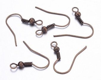 May include: Close-up of five antique bronze-colored earring hooks. Each hook features a curved wire design with a small ball and a coiled spring detail. The hooks are arranged against a plain white background, highlighting their intricate design.