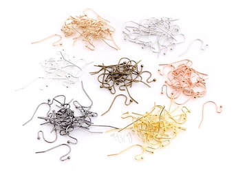 May include: A collection of earring hooks in various metallic finishes, including gold, silver, bronze, and black. The hooks are scattered on a white surface, showcasing their different colors and styles. The image is well-lit, highlighting the details of each hook.