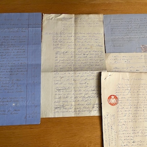 May include: A collection of antique handwritten documents on various paper types, including a blue ledger sheet with columns, several cream-colored letters with cursive ink script, and a document featuring a circular red wax seal.