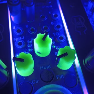 Könnte beinhalten: Nahaufnahme eines Musikmischpults mit grünen Knöpfen, die mit "Hold", "Fill" und "Clr" beschriftet sind. Die Knöpfe sind in einem leuchtenden Blau beleuchtet.