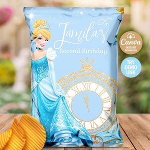 Può includere: Un sacchetto di patatine blu chiaro con Cenerentola, un orologio e la scritta "Jamilas Second Birthday". La borsa ha dettagli dorati e un logo Canva. Tre patatine ondulate sono davanti alla borsa.