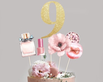 May include: Gold glitter number nine cake topper with pink and white flowers, a pink nail polish bottle, a pink and white perfume bottle, and a pink and white makeup compact.