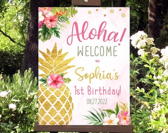 Peut inclure: Une pancarte d'accueil rose et or avec un motif d'ananas et des accents floraux. La pancarte indique "Aloha ! Bienvenue à Sophia's 1er anniversaire ! 08.27.2022".