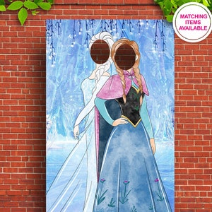 Puede incluir: Un recorte de cart&oacute;n de dos princesas, Elsa y Anna, de la pel&iacute;cula Frozen. El recorte tiene dos agujeros para las caras, permitiendo a la gente poner sus caras a trav&eacute;s de los agujeros y tomar fotos. El fondo es una imagen de estilo acuarela de un bosque nevado.