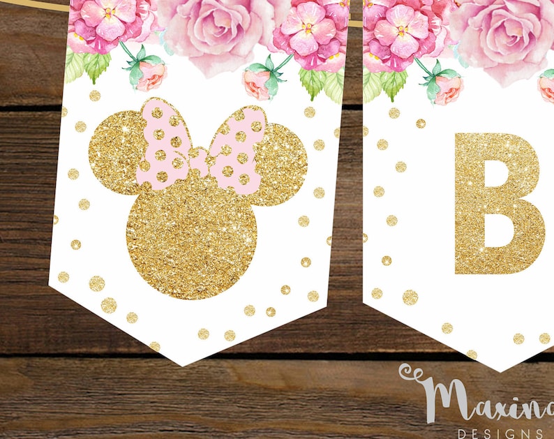 Puede incluir: Una pancarta blanca con orejas de Mickey Mouse de purpurina dorada y un lazo rosa. La pancarta tambi&eacute;n tiene una letra "B" de purpurina dorada y un dise&ntilde;o floral con flores rosas y hojas verdes.