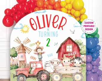 Puede incluir: Un diseño imprimible personalizado para una fiesta de cumpleaños con temática de granja. El diseño incluye un tractor rojo, un granero, un molino de viento y animales de granja. El texto "Oliver cumple 2 años" se muestra en rojo y verde.